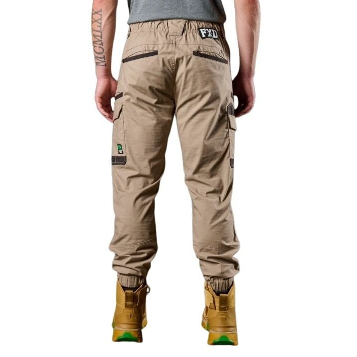 Person wearing beige cargo pants with visible branding on a white background