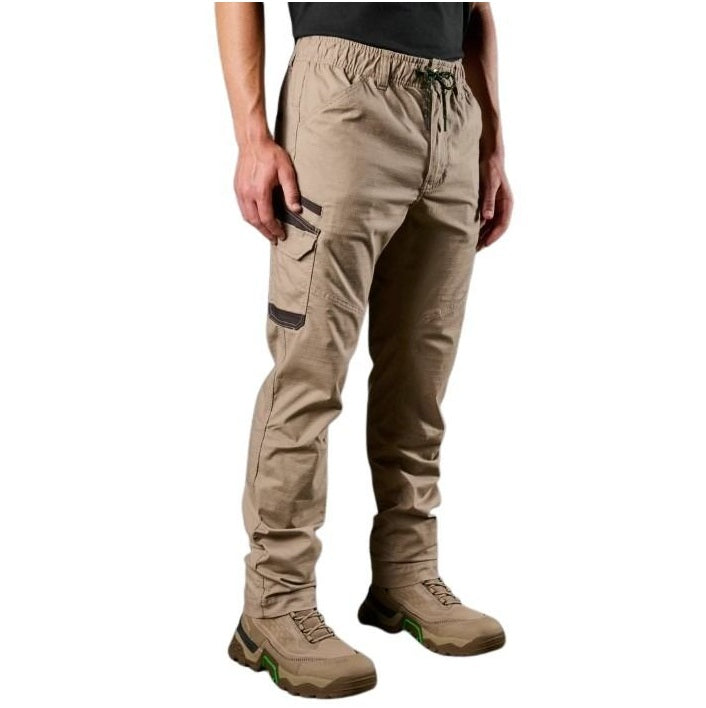 Person wearing beige pants with green accents on a white background