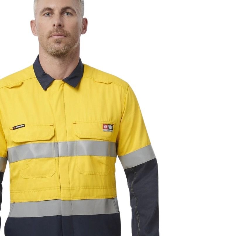 Person wearing a yellow and navy work jacket with reflective stripes on a white background