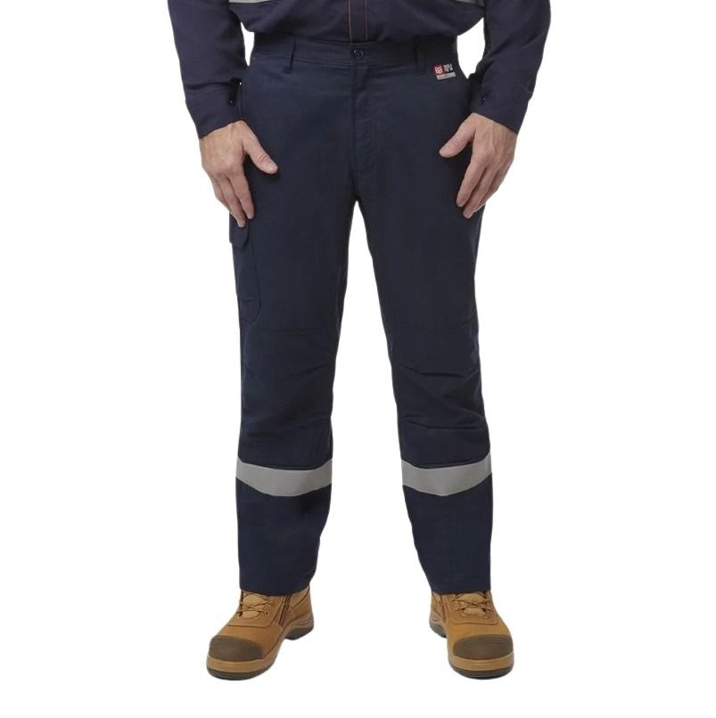 Person wearing navy work pants with reflective stripes on a white background